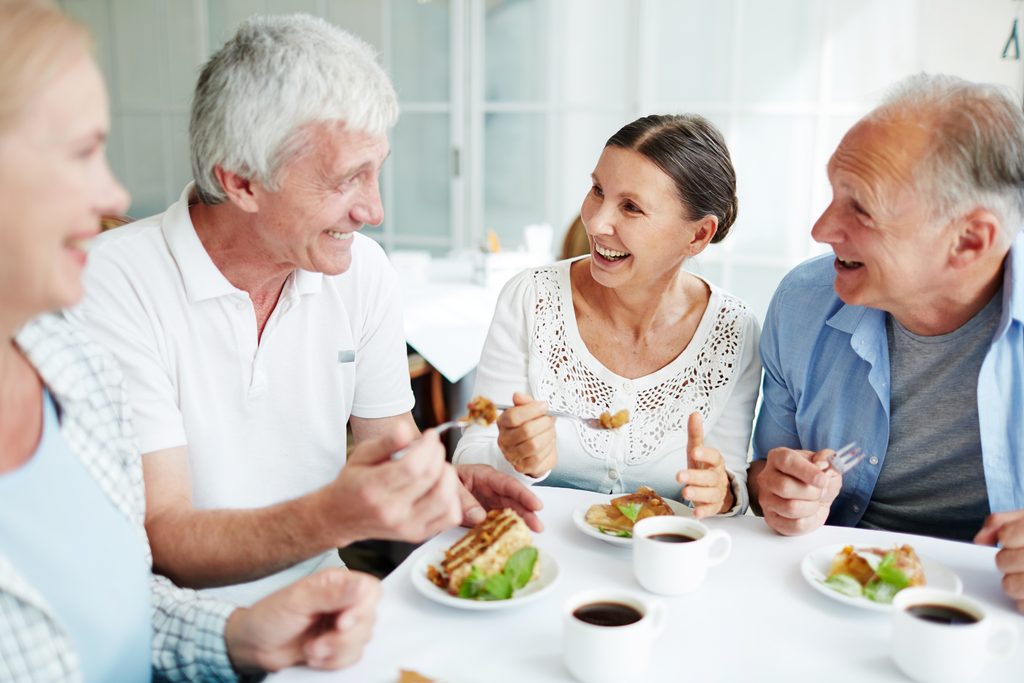 Woman caregiver eating dessert with friends.